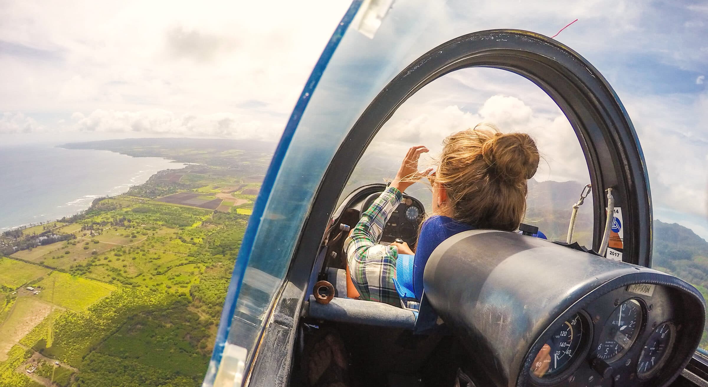 Passenger's view from inside the glass canopy of a glider over the North Shore coastline